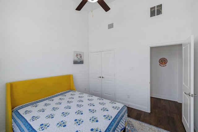 bedroom with ceiling fan, a closet, wood finished floors, and visible vents