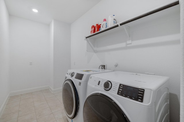 clothes washing area featuring washer and dryer, laundry area, baseboards, and light tile patterned floors