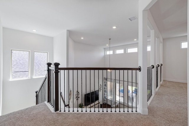 hall with carpet floors, recessed lighting, visible vents, and an upstairs landing