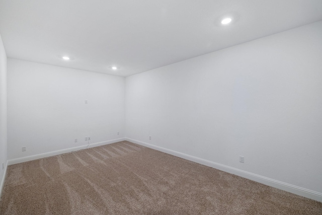 unfurnished room featuring recessed lighting, light colored carpet, and baseboards