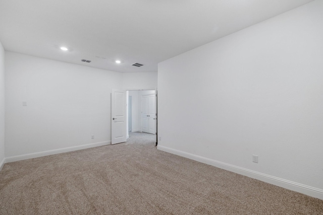 empty room featuring light carpet, baseboards, visible vents, and recessed lighting