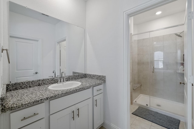 full bath featuring visible vents, a shower stall, vanity, tile patterned flooring, and baseboards