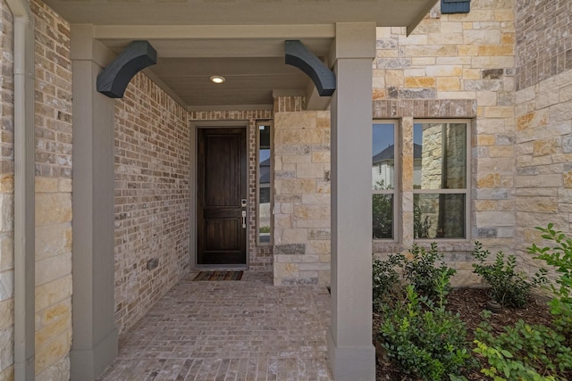 entrance to property with stone siding and brick siding