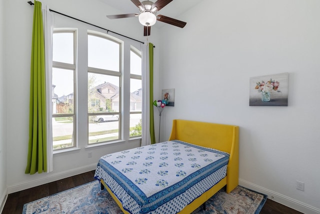 bedroom featuring a ceiling fan, dark wood-style flooring, and baseboards