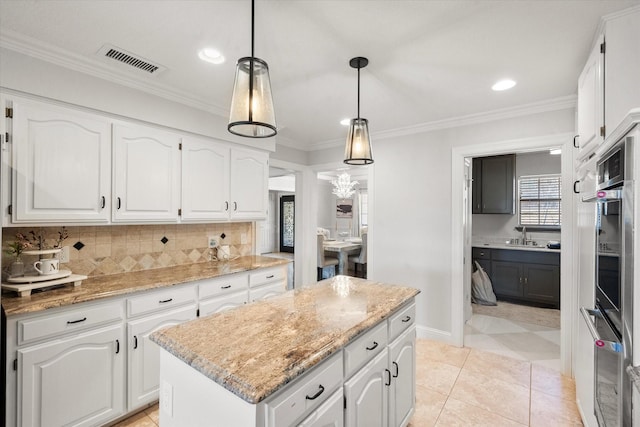 kitchen featuring white cabinets, visible vents, and a kitchen island