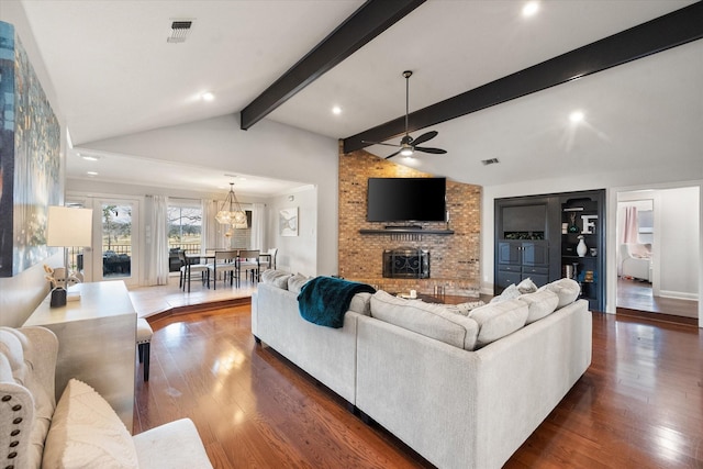 living area with visible vents, a ceiling fan, lofted ceiling with beams, wood-type flooring, and a fireplace