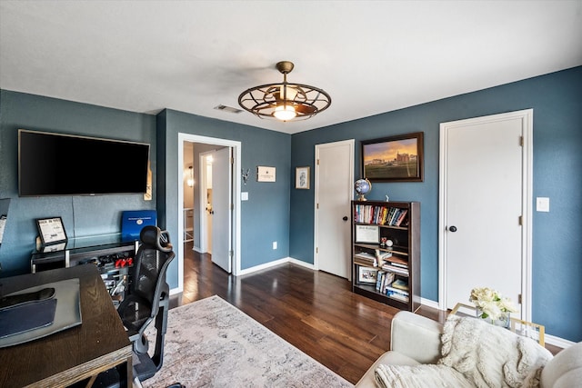 office space featuring a ceiling fan, wood finished floors, visible vents, and baseboards