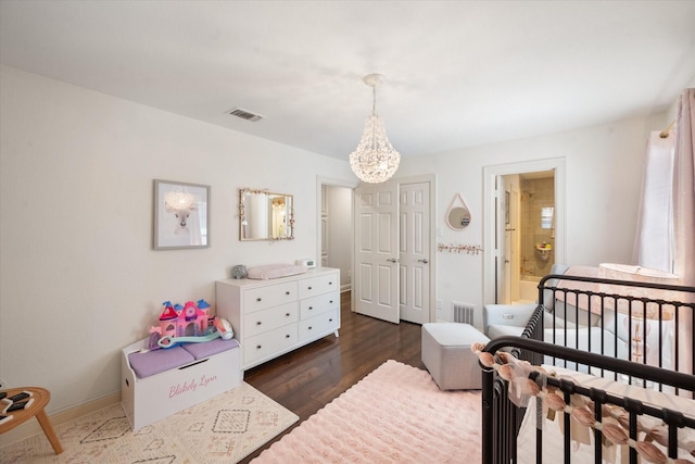 bedroom with dark wood-style floors, baseboards, visible vents, and an inviting chandelier