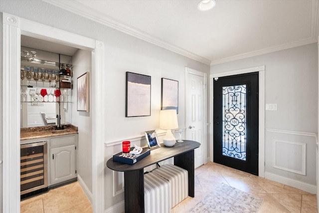 entrance foyer with wet bar, light tile patterned flooring, crown molding, and wine cooler