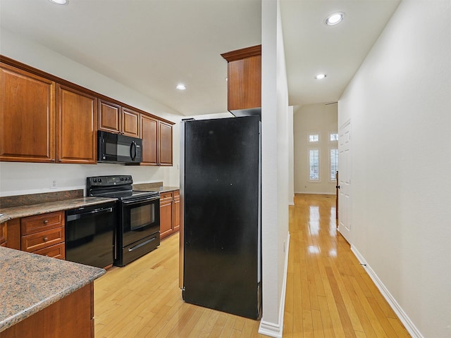 kitchen with black appliances, light wood-type flooring, and recessed lighting