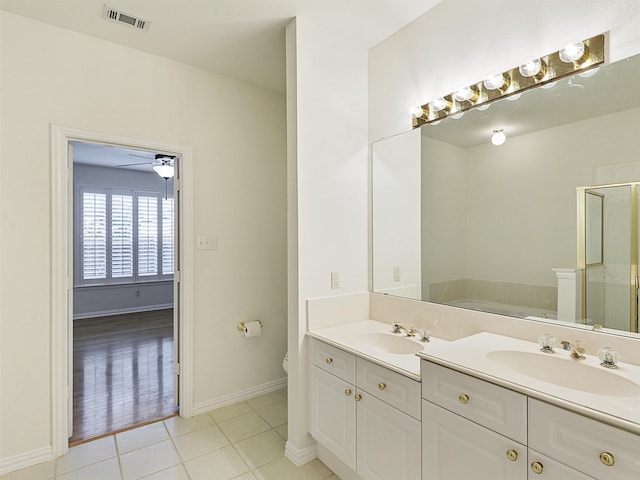 bathroom featuring a stall shower, tile patterned flooring, a sink, and visible vents