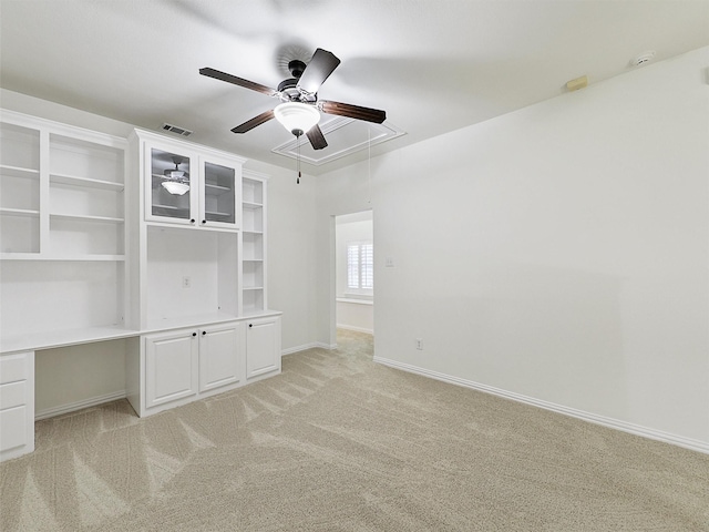 interior space with attic access, visible vents, baseboards, a ceiling fan, and light colored carpet