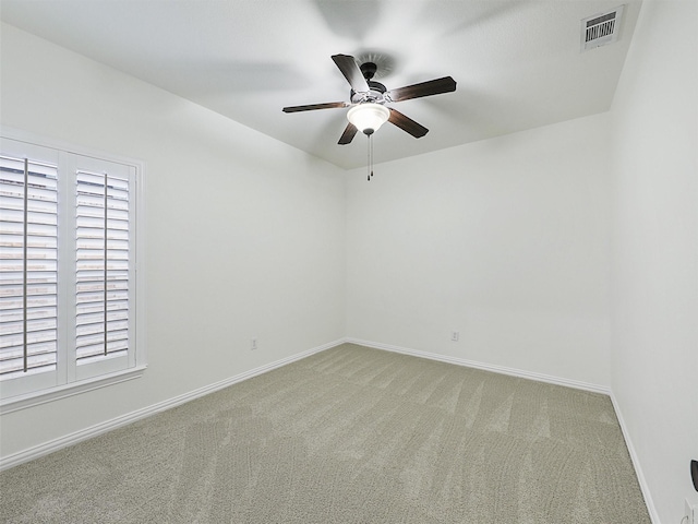 unfurnished room with baseboards, a healthy amount of sunlight, visible vents, and light colored carpet