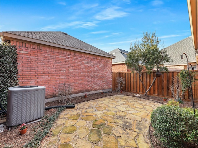 view of patio with a fenced backyard and central AC unit