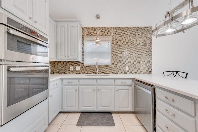 kitchen with light tile patterned floors, double oven, decorative backsplash, and a sink