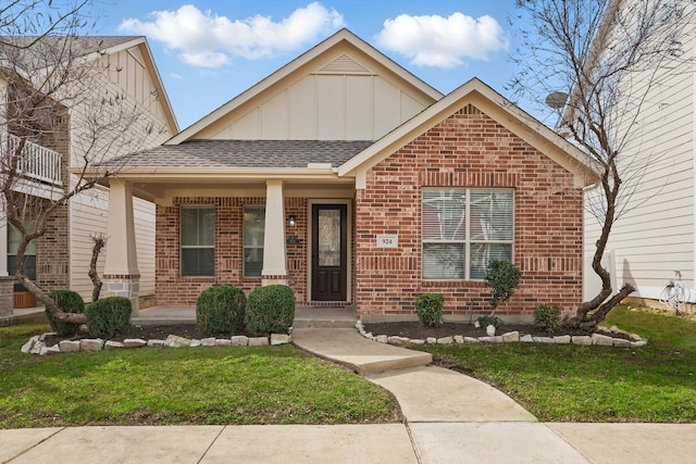 view of front of home with brick siding, board and batten siding, and a front lawn