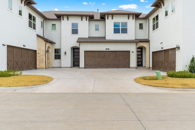 view of front facade featuring a garage, concrete driveway, and stucco siding