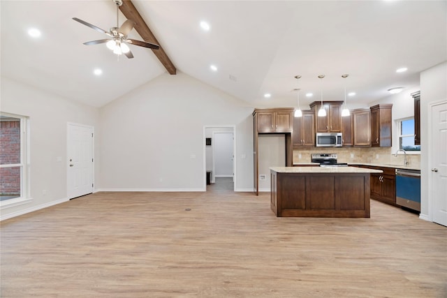 kitchen with open floor plan, stainless steel appliances, backsplash, and beam ceiling