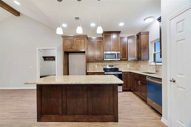 kitchen featuring tasteful backsplash, visible vents, lofted ceiling with beams, appliances with stainless steel finishes, and a sink