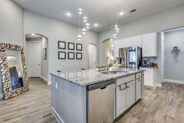 kitchen with appliances with stainless steel finishes, arched walkways, visible vents, and a sink