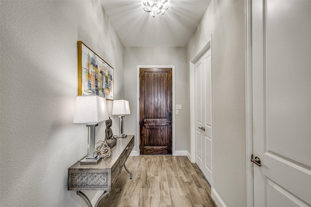 doorway with light wood-type flooring and baseboards