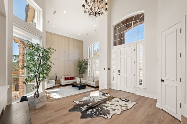 foyer entrance with wood finished floors, recessed lighting, a high ceiling, an inviting chandelier, and baseboards