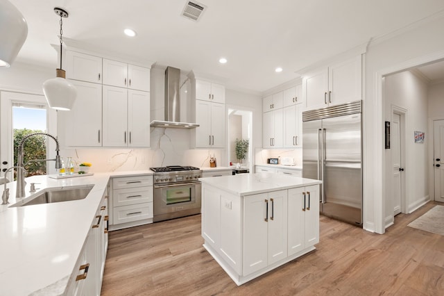 1503 Kingswood Ln, Colleyville, TX 76034 - kitchen featuring high quality appliances, wall chimney exhaust hood, a sink, crown molding, and light countertops