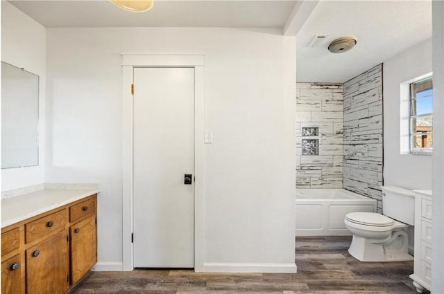 bathroom featuring shower / washtub combination, vanity, toilet, wood finished floors, and baseboards