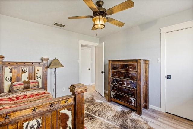 bedroom featuring visible vents, ceiling fan, light wood-type flooring, and baseboards