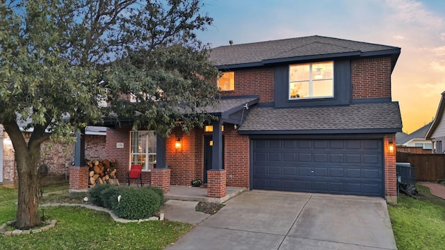 traditional-style home featuring concrete driveway, roof with shingles, and brick siding