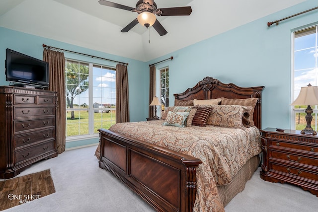 bedroom featuring a ceiling fan, lofted ceiling, light carpet, and multiple windows