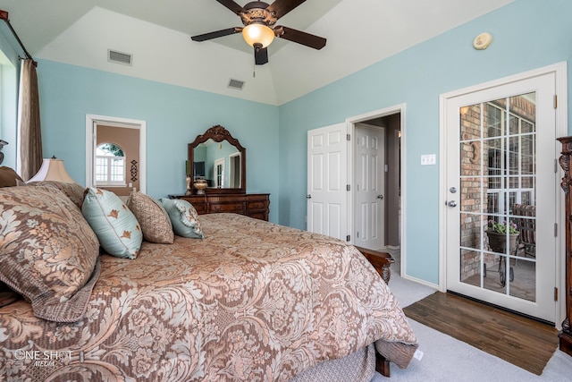 bedroom featuring vaulted ceiling, access to outside, wood finished floors, and visible vents