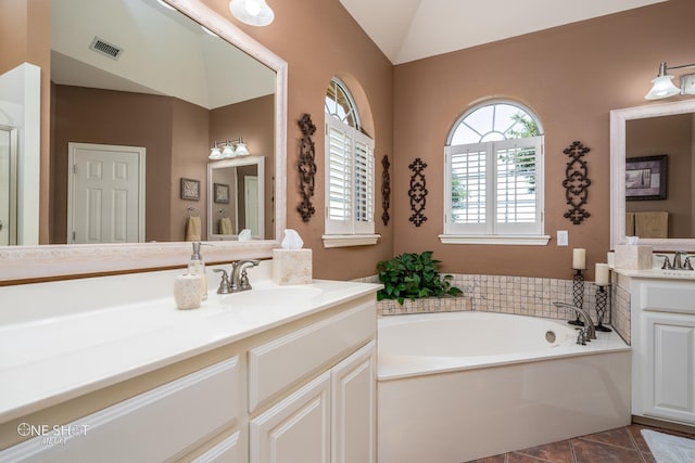 full bath featuring a bath, two vanities, a sink, and visible vents