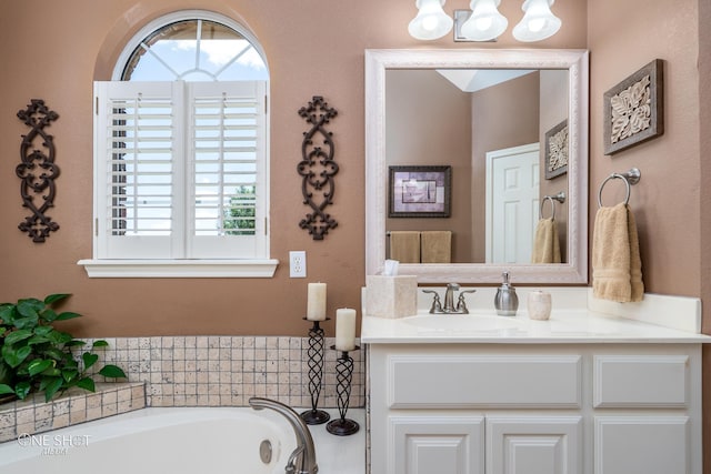 bathroom with a healthy amount of sunlight, vanity, and a bath