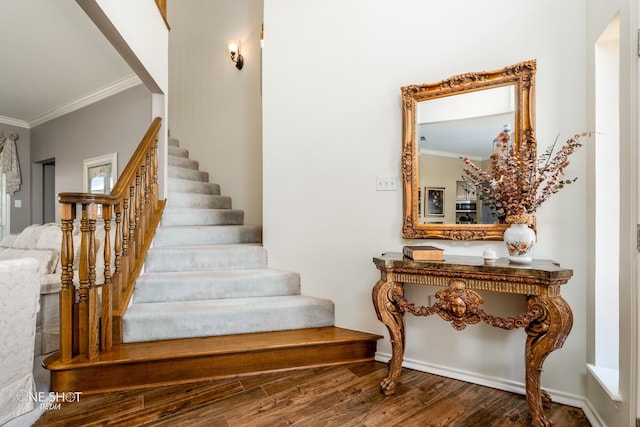 staircase with ornamental molding, wood finished floors, and baseboards