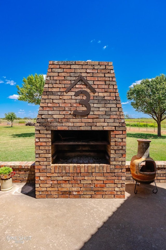 exterior details featuring an outdoor brick fireplace