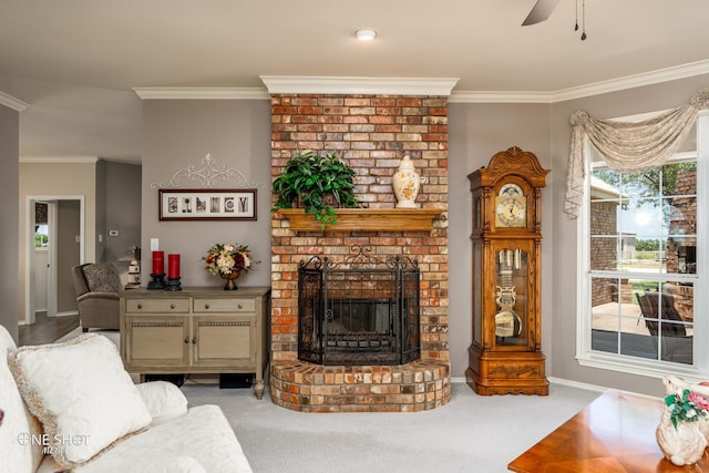 living area featuring a fireplace, a ceiling fan, baseboards, carpet, and crown molding