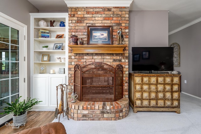 living area featuring crown molding, a fireplace, carpet floors, and baseboards