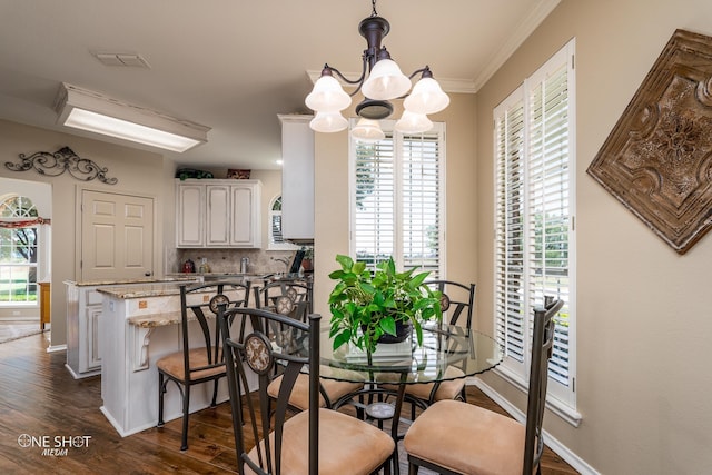 dining area featuring visible vents, ornamental molding, dark wood-type flooring, a chandelier, and baseboards