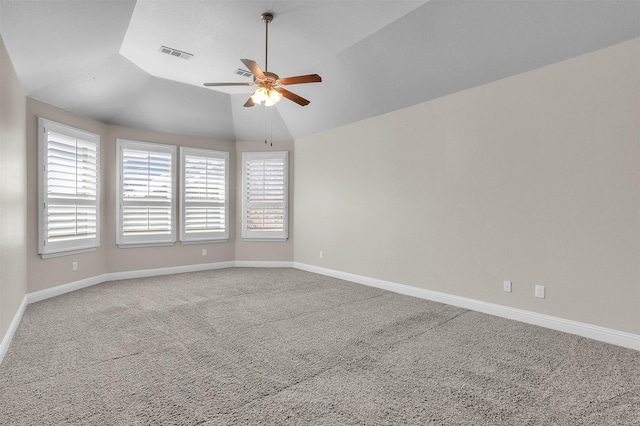 unfurnished room featuring lofted ceiling, visible vents, a ceiling fan, carpet flooring, and baseboards