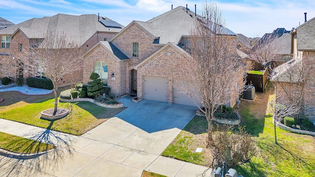 view of front of house featuring driveway, an attached garage, cooling unit, a front lawn, and brick siding