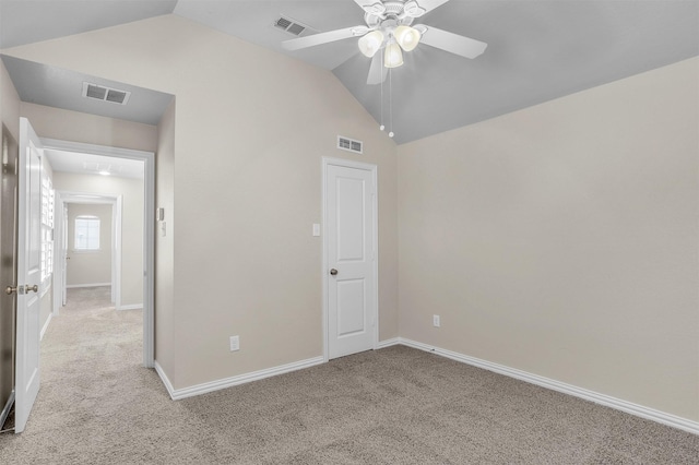 unfurnished bedroom with light carpet, vaulted ceiling, visible vents, and baseboards