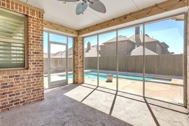 unfurnished sunroom featuring ceiling fan