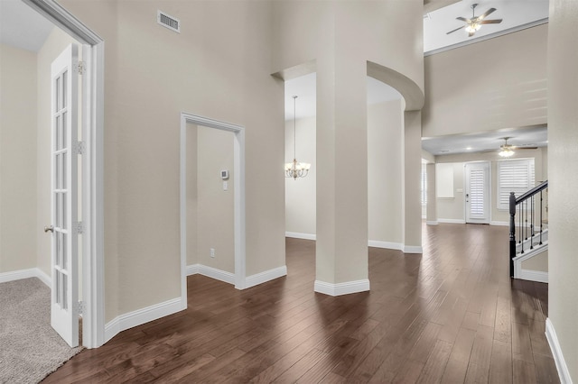 entrance foyer with a high ceiling, visible vents, baseboards, stairs, and dark wood-style floors