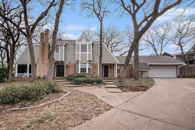 tudor-style house featuring a garage, brick siding, concrete driveway, a chimney, and stucco siding