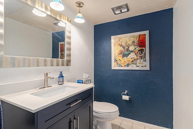 half bathroom with a textured wall, toilet, vanity, tile patterned flooring, and baseboards