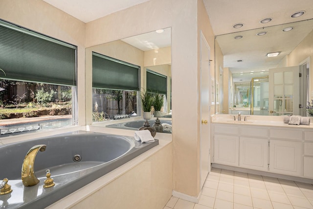 bathroom with a whirlpool tub, tile patterned flooring, recessed lighting, and vanity