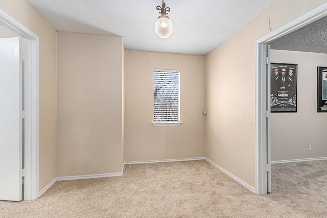 spare room with carpet and baseboards