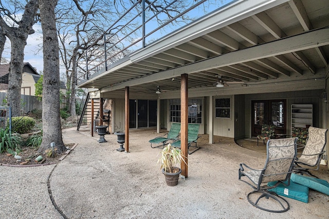 view of patio featuring ceiling fan, stairs, and fence