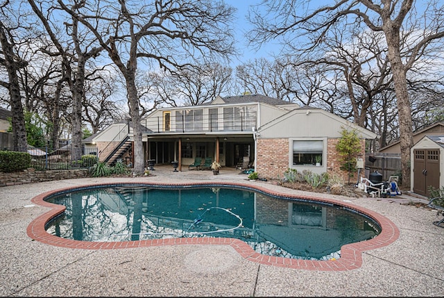 view of swimming pool featuring a fenced in pool, a patio, stairway, an outbuilding, and fence